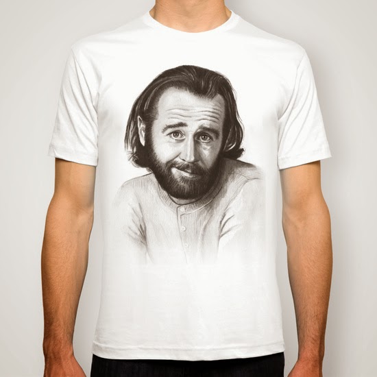 A white T-shirt with a pencil portrait of a young, bearded George Carlin