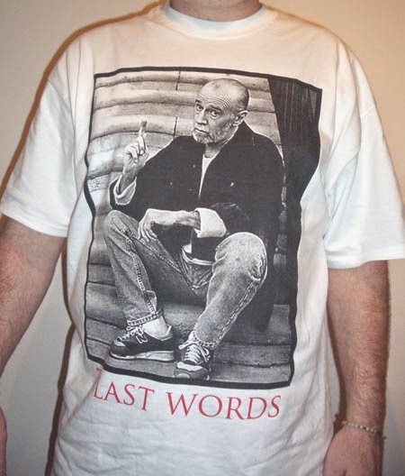 A man wearing a Last Words T-shirt showing Carlin sitting on a stoop