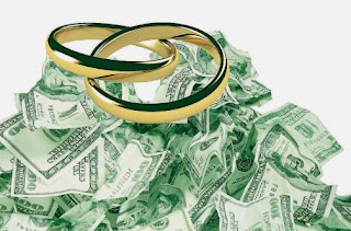 Two gold wedding rings resting on a heap of dollar bills